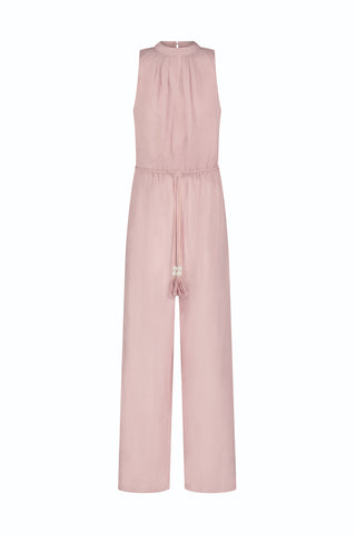 The Fernanda Linen Jumpsuit - Blush is a sleeveless, light pink linen piece with a gathered neckline, drawstring waist with tassels, wide-leg pants, and an elegant, simple design.