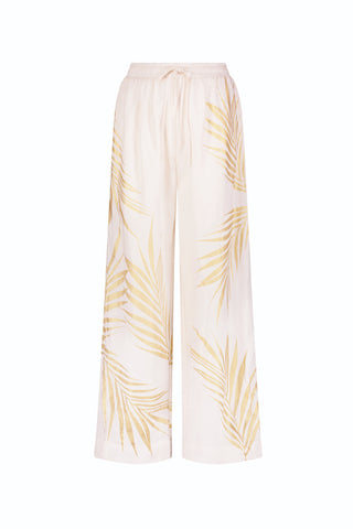 Preorder the Sola Linen Pant - Gold Palm: wide-leg, light beige pants with an elastic waistband, drawstring, and yellow palm leaf print. Ships by June 25.