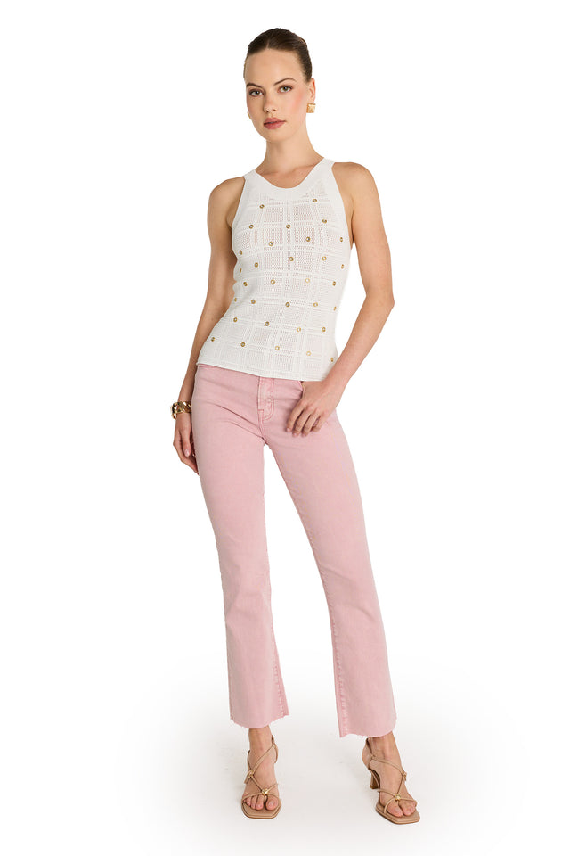 A woman poses with one hand on her hip against a white background, wearing the Mary Embellished Top - Pearl, light pink cropped jeans, beige strappy sandals, and gold hoop earrings.