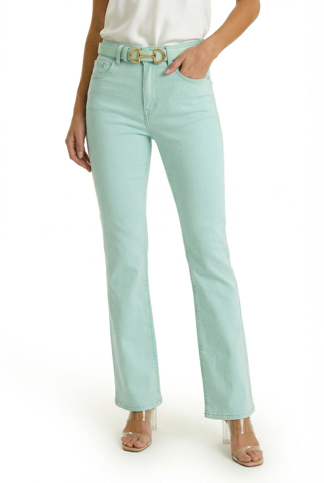 Someone wears the Aria Flare Jean - Mint, styled with a matching belt, white top, and clear-heeled sandals, standing against a white background.