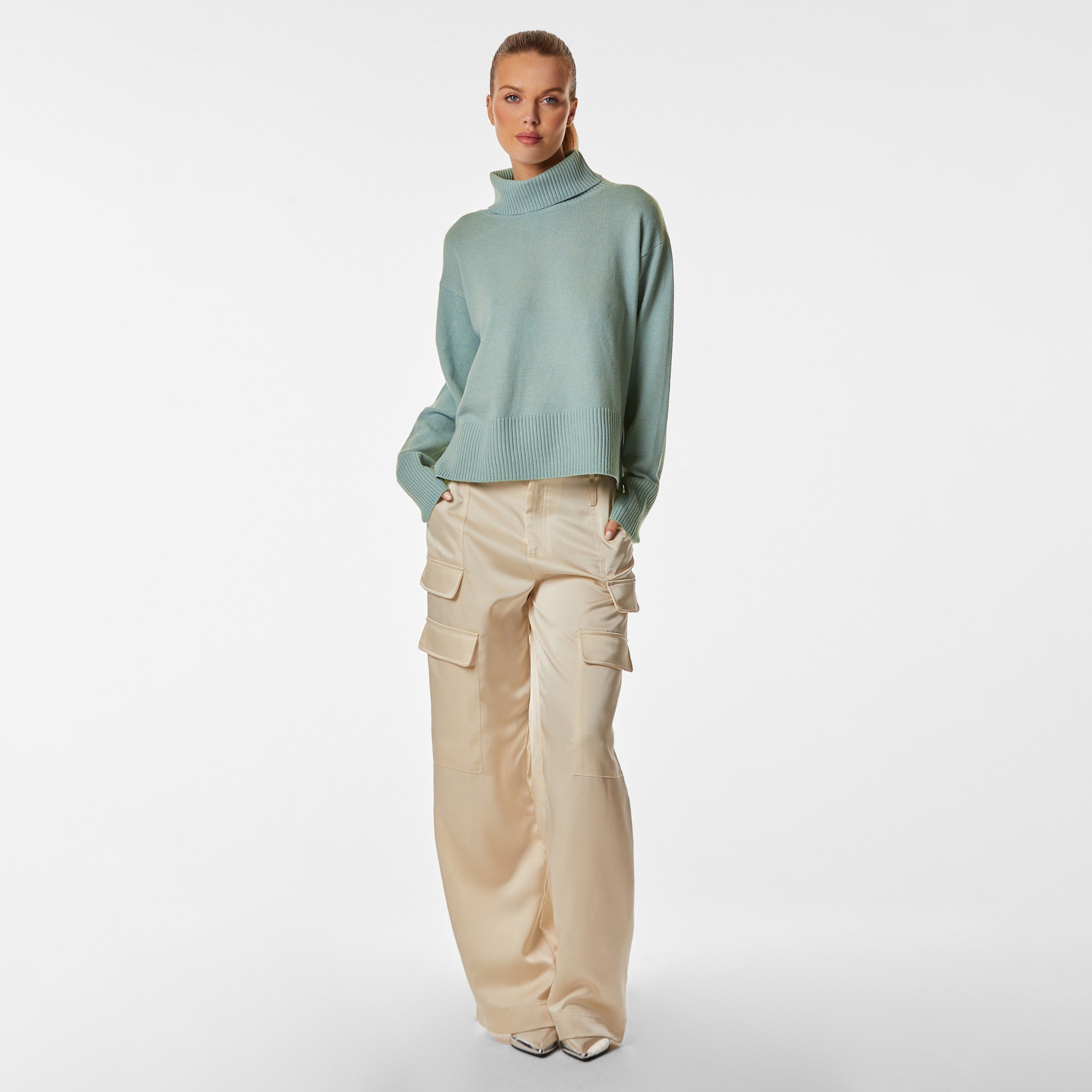 Woman wearing green oversized sweater and pearl satin cargo pant