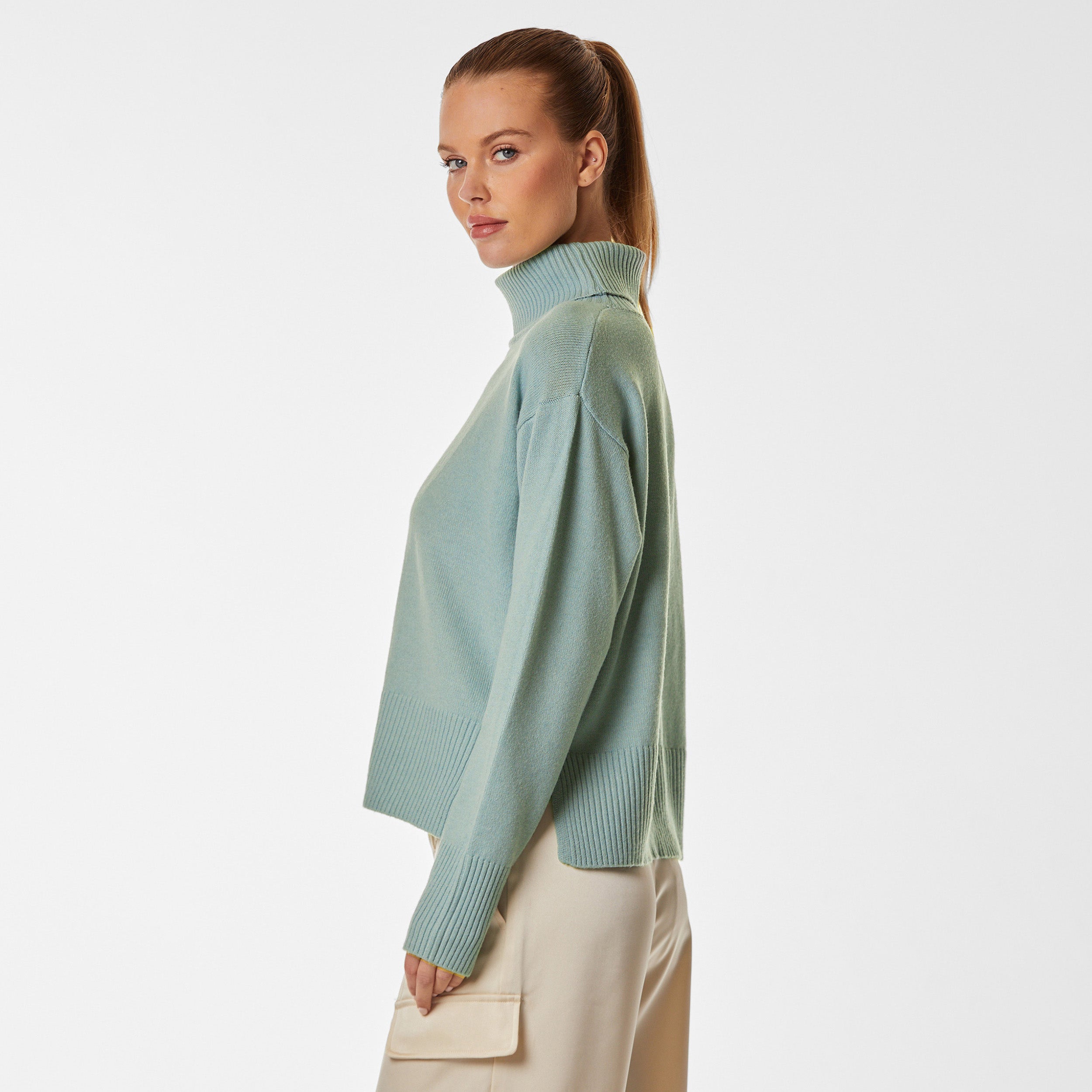 Side view of woman wearing green oversized sweater