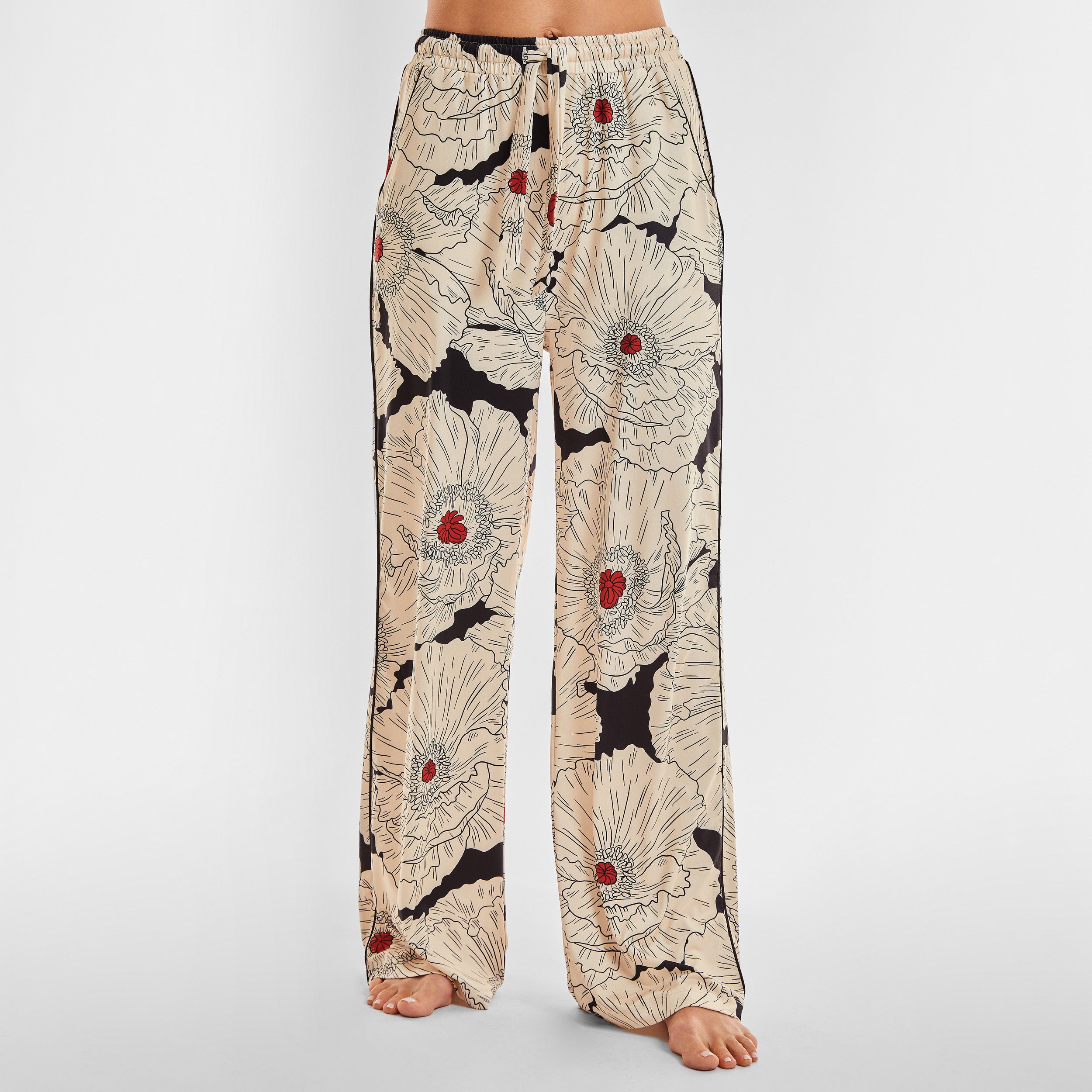 Front view of woman wearing breathable, relaxed and buttery smooth pajama pant featuring high-waist cut, side pockets, front tie and stunning Poppy floral print.