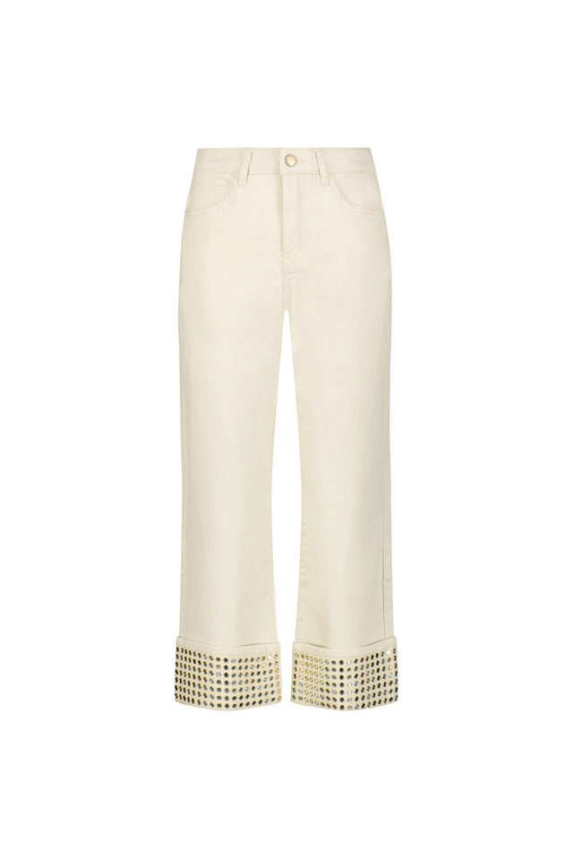 The Ren Cropped Cuff Jean - Gold Mirror is a cream-colored, four-way stretch denim with wide turned-up hems adorned with metallic gold studs, shown against a plain white background.