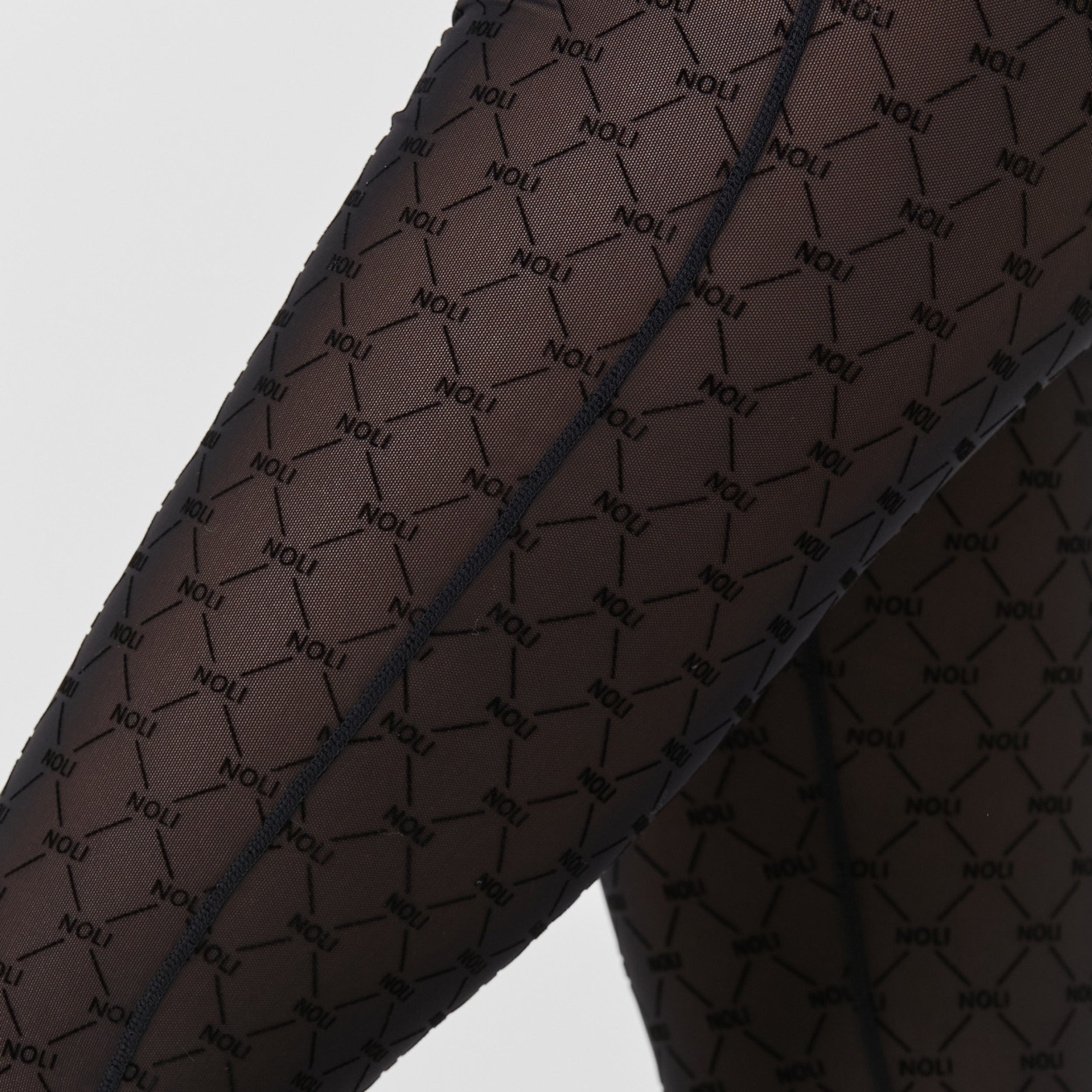 Close up view of woman wearing tights featuring ultra-soft and comfortable NOLI monogram mesh, slip this four-way stretch mesh