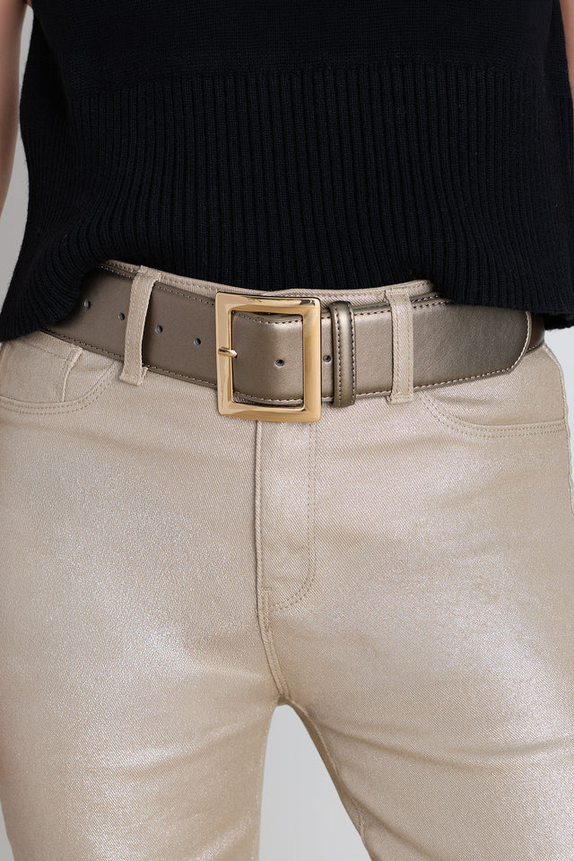 The Josie Belt in bronze worn at the waist, showing the wide strap and square gold buckle
