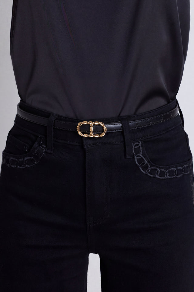 The Mabel Belt in black and gold worn at the waist, showing the twisted gold buckle