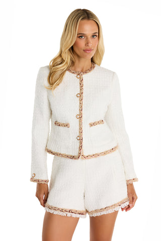 A woman with long blonde hair wears the Joane Tweed Jacket - Pearl Multi, styled with matching shorts trimmed in pink and beige. She stands against a plain white background.