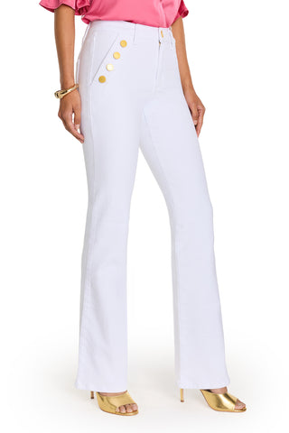 A person wearing the Allegra Bootcut Jean - White with gold side detailing, a pink blouse, gold bracelet, and gold high-heeled sandals, standing against a white background.