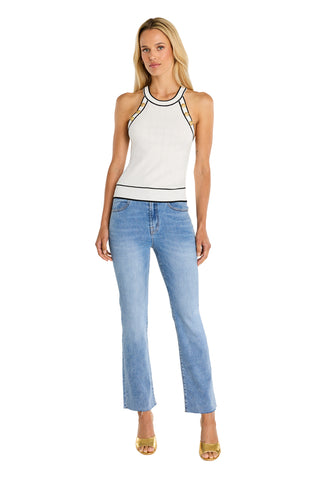 A woman with long blonde hair and a neutral expression stands against a white background wearing the Martha Button Halter Tank in white, light blue jeans, and yellow heeled sandals.
