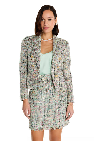 A woman stands against a white background wearing the Gabrielle Double Breasted Tweed Blazer in Teal Multi, styled with a light green top, pearl necklace, and bracelet.