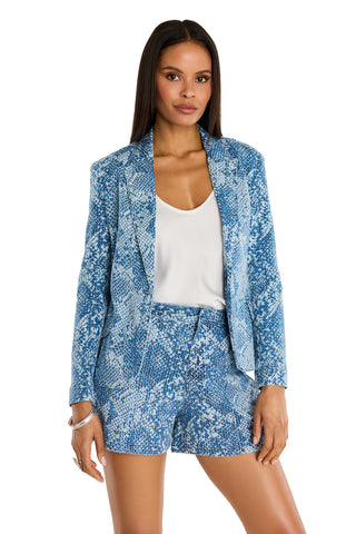 A woman with long, straight hair and a neutral expression stands facing forward, wearing the Marie Single Breasted Blazer - Crystal Snake with matching shorts and a white top.