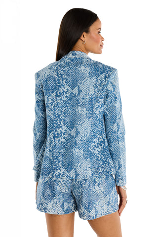 A woman with long dark hair, seen from behind, wears the Marie Single Breasted Blazer – Crystal Snake with matching shorts against a plain white background.