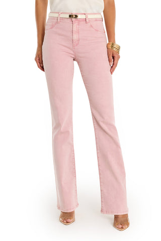 A woman stands against a white background, shown from shoulders to feet, wearing the Aria Flare Jean - Blush, a white top, gold bracelets, and open-toe nude heels.