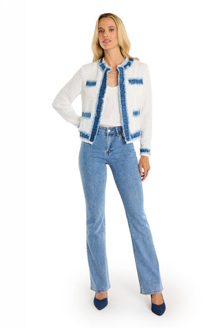 A woman wears the Julia Tweed Jacket in Denim/White with blue fringe trim, paired with a white top, light blue high-waisted jeans, and dark blue pointed-toe heels against a white background.
