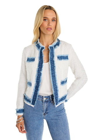 A woman with long blonde hair models the Julia Tweed Jacket - Denim/White, featuring blue denim trim and fringe, over a white top and light blue jeans. She stands facing forward with one hand on her hip against a white background.