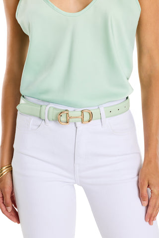 A woman wears a mint sleeveless top tucked into high-waisted white jeans, accessorized with the Bettie Belt - Mint featuring a gold buckle, and gold bangles on her wrist.