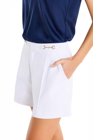 A person in a navy blue top and Ellery Horsebit Short - White stands with one hand in their pocket.