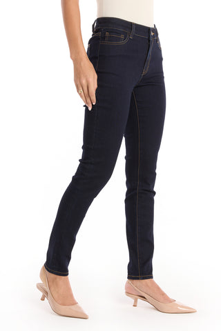 A person models the Layla Skinny Jean - Indigo with light beige low-heeled shoes, standing against a white background. Only the lower half is visible.