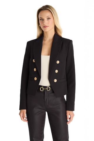 A woman with long blonde hair wears the Gabrielle Double Breasted Blazer in black over a white top and black pants, standing against a plain white background.