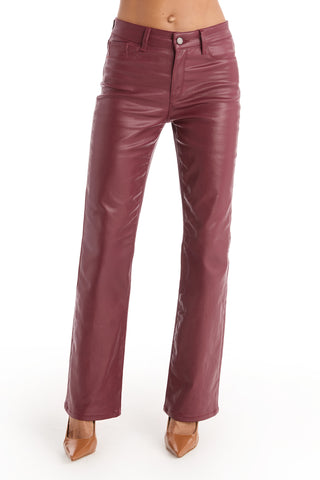 A person wearing Aria Coated Flare Jean in Merlot and tan pointed-toe heels stands against a plain white background.