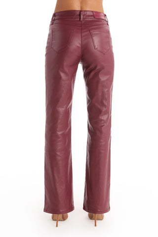 Someone wearing the Aria Coated Flare Jean in Merlot with a high-rise fit and nude heels, shown from the back against a white background.