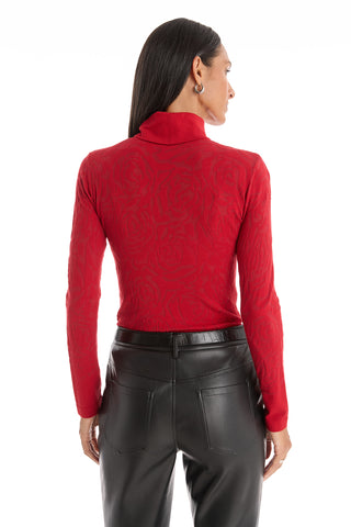 A woman with straight dark hair is seen from the back, wearing the slim-fitting Alina Rose Turtleneck Top in red and high-waisted black leather pants against a white background.