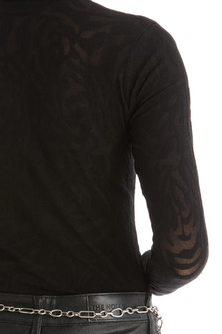 A person wearing the Alina Rose Turtleneck Top - Black, styled with black pants and a silver chain belt, shown from the back against a white background.