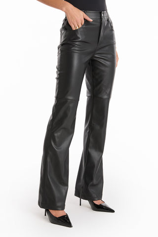 Model wears the Jackie Leather Pant - Black, a high-rise flare style, paired with pointed black heels. Photo is cropped from the chest down, set against a white background.