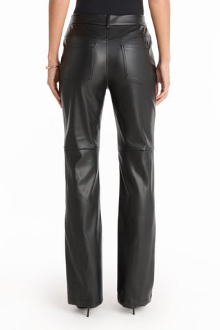 A person, visible from the waist down, stands against a white background wearing Jackie Leather Pant - Black and black heels, hands at their sides.