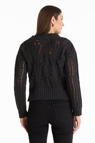 A woman wearing the Elea Crystal Knit Sweater in black.