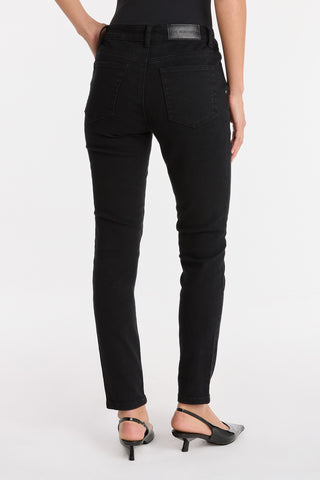 A person is shown from the back against a plain white background wearing the Layla Skinny Jean - Black and black open-toe heels.