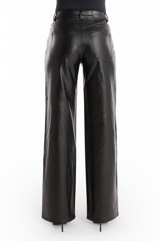 A person seen from the back wears the Kaia Studded High Rise Leather Pant in black, featuring wide legs, visible back pockets, and seam detailing against a white background.