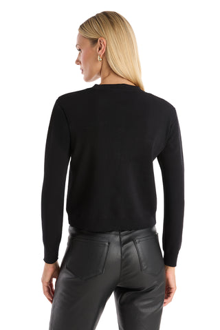 A woman with straight blonde hair is shown from the back against a white background, wearing the Loretta Knit Cardigan Top in black with long sleeves and padded shoulders, paired with black leather pants.