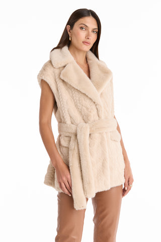 A woman wears the Leone Cable Knit Cardigan in Pearl, styled with light brown pants, standing against a white background.