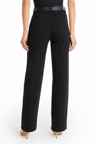A person is shown from the back against a white background wearing Leah Studded Jean - Black high-rise jeans with beige heels. The jeans offer four-way stretch denim, back pockets, and a straight-leg fit.