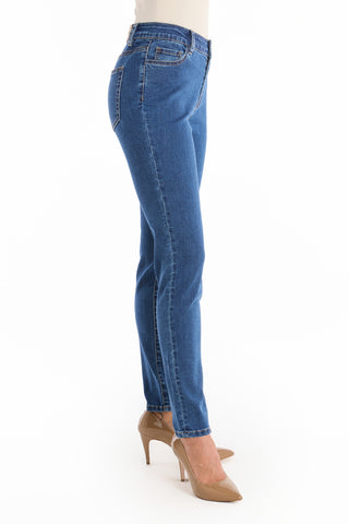 A person wearing Layla Skinny Jean - Medium Blue and tan high-heeled shoes is standing sideways against a white background.