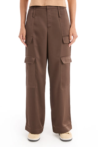 Someone models the Milan Satin Cargo Pant in Espresso, featuring multiple pockets, paired with white sneakers, and stands facing forward against a plain white background.