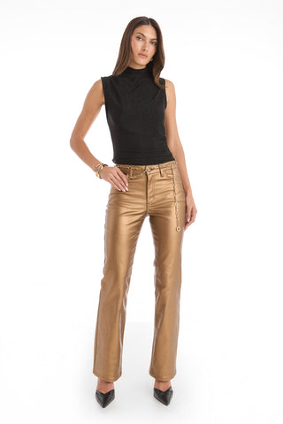 A woman with long brown hair and a neutral expression stands against a white background wearing the Mia Shimmer Tank in black, paired with metallic gold pants, black pointed-toe heels, a chain belt, and bracelets.