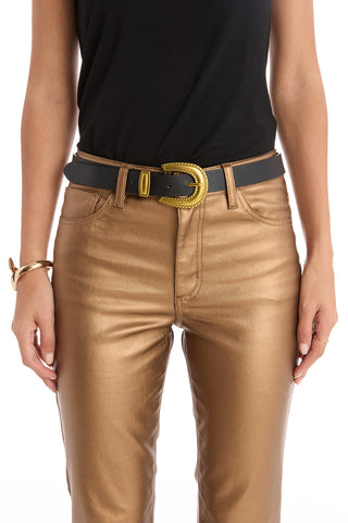 A person wears metallic gold pants, a black top, gold jewelry, and the Shelly Belt - Black with a gold cowboy buckle. The cropped image focuses on the torso and upper legs.