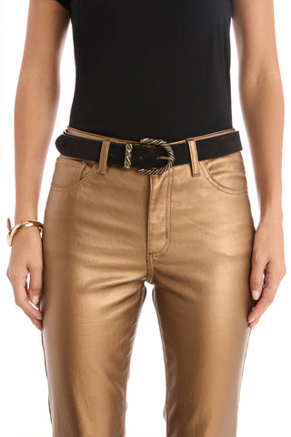 A person wears a black short-sleeve top, metallic gold pants, the Samantha Belt - Black with a gold western buckle, and gold jewelry on their wrist and finger. The image is cropped at the shoulders and above the knees.