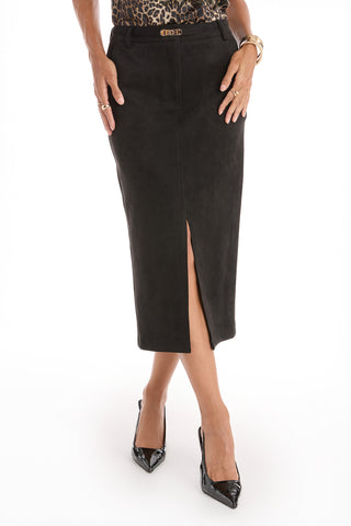 A woman wearing the Kendra Sueded Midi Skirt in black with a front slit, paired with black pointed-toe heels, a leopard print top, and gold jewelry, stands against a white background.