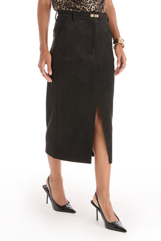 A person stands against a white background wearing the Kendra Sueded Midi Skirt - Black with a front slit, paired with black slingback heels, a leopard print top, and gold bracelets.
