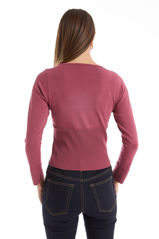 A woman with straight brown hair is shown from the back, wearing the Edie Knit Top in Sangria and dark blue jeans with yellow stitching, standing against a white background.