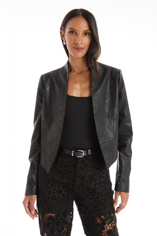 A woman faces forward wearing the Yasmin Leather Jacket - Black over a black top and black lace pants with a belt, set against a plain white background.