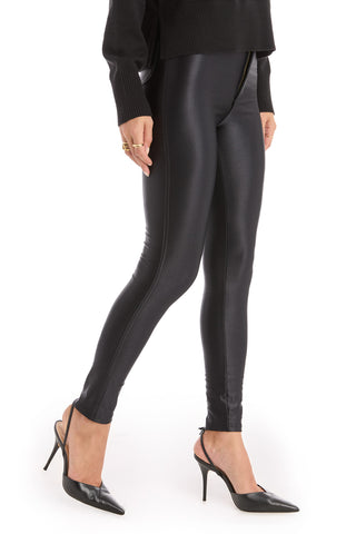 Wearing the Suzette Skinny Pant in black with a high-rise waist, styled with a black long-sleeve top and high-heeled slingback shoes, a person poses against a white background. Only the lower half of the body is shown.