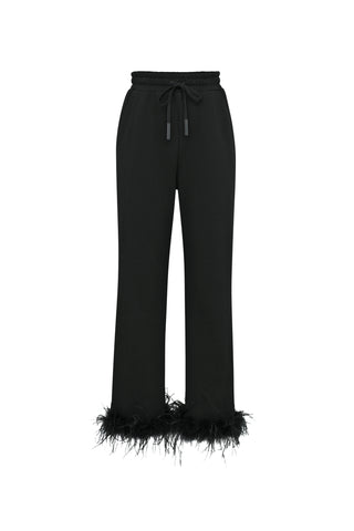 The Rada Feather Trim Pant - Black, made from French Terry, includes an elastic waistband and drawstring. It is adorned with elegant ostrich feather trim at the cuffs, effortlessly combining casual charm with sophisticated details.