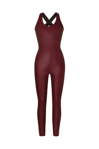 The Vixen Jumpsuit - Cherry is a maroon sleeveless piece, featuring a crisscross strap design at the back. Made from liquid shine fabric, it combines style with functionality, serving as a squat-proof unitard for confident wear.