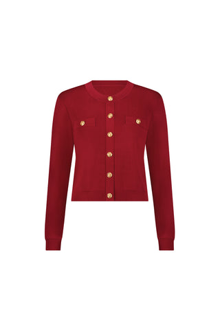 The Loretta Knit Cardigan Top in Merlot features long sleeves, padded shoulders, gold buttons, and two chest pockets, shown against a plain white background.