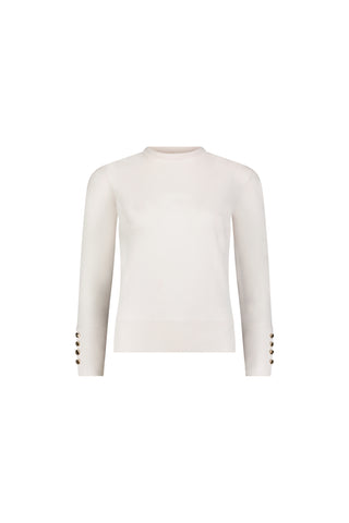 The Marcela Knit Top - Pearl is a fitted cream sweater with long sleeves, a crew neck, and stylish gold buttons on the cuffs, shown against a white background.